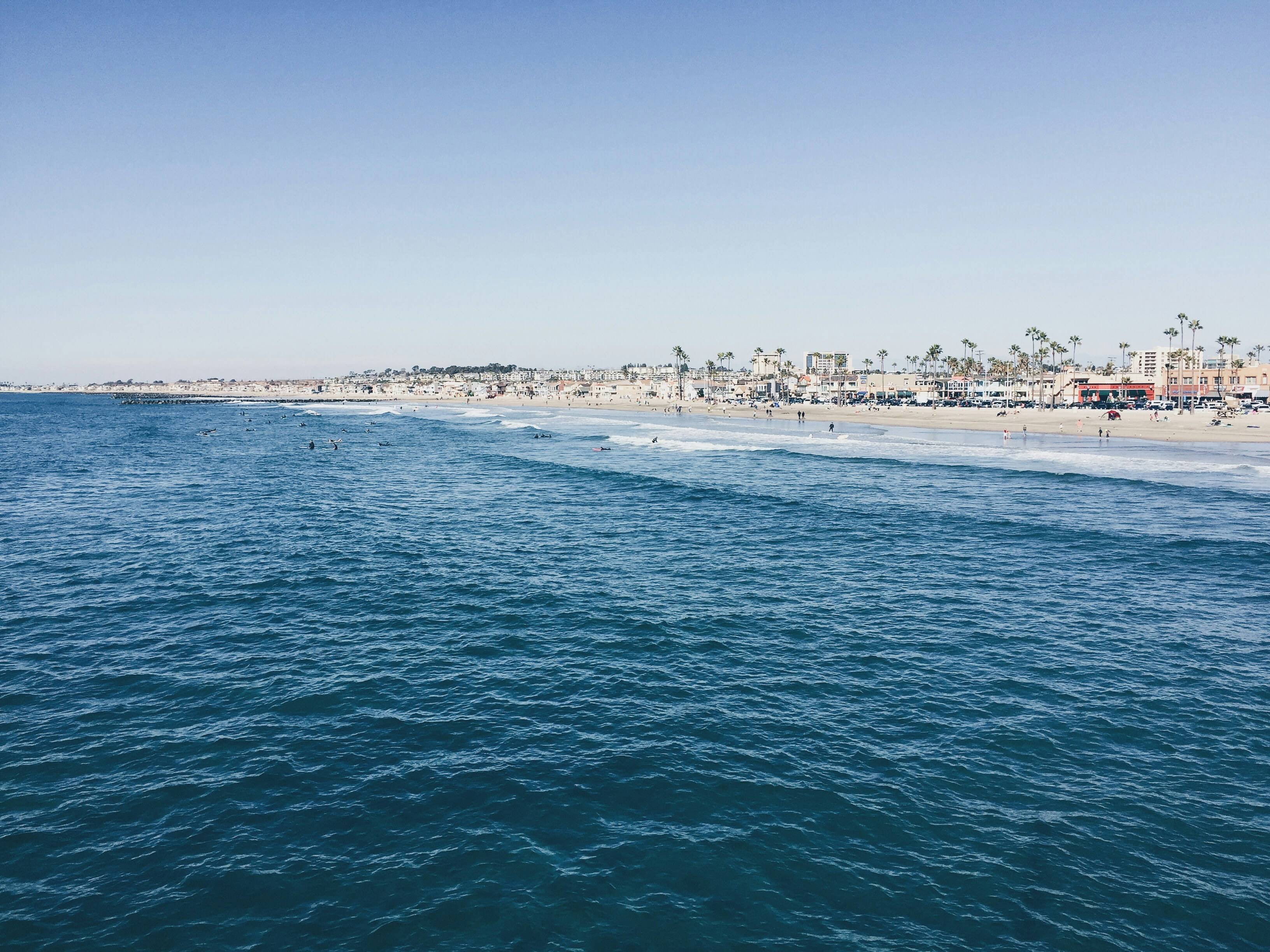 Surf instructor teaching a beginner to surf at Newport Beach with gentle waves