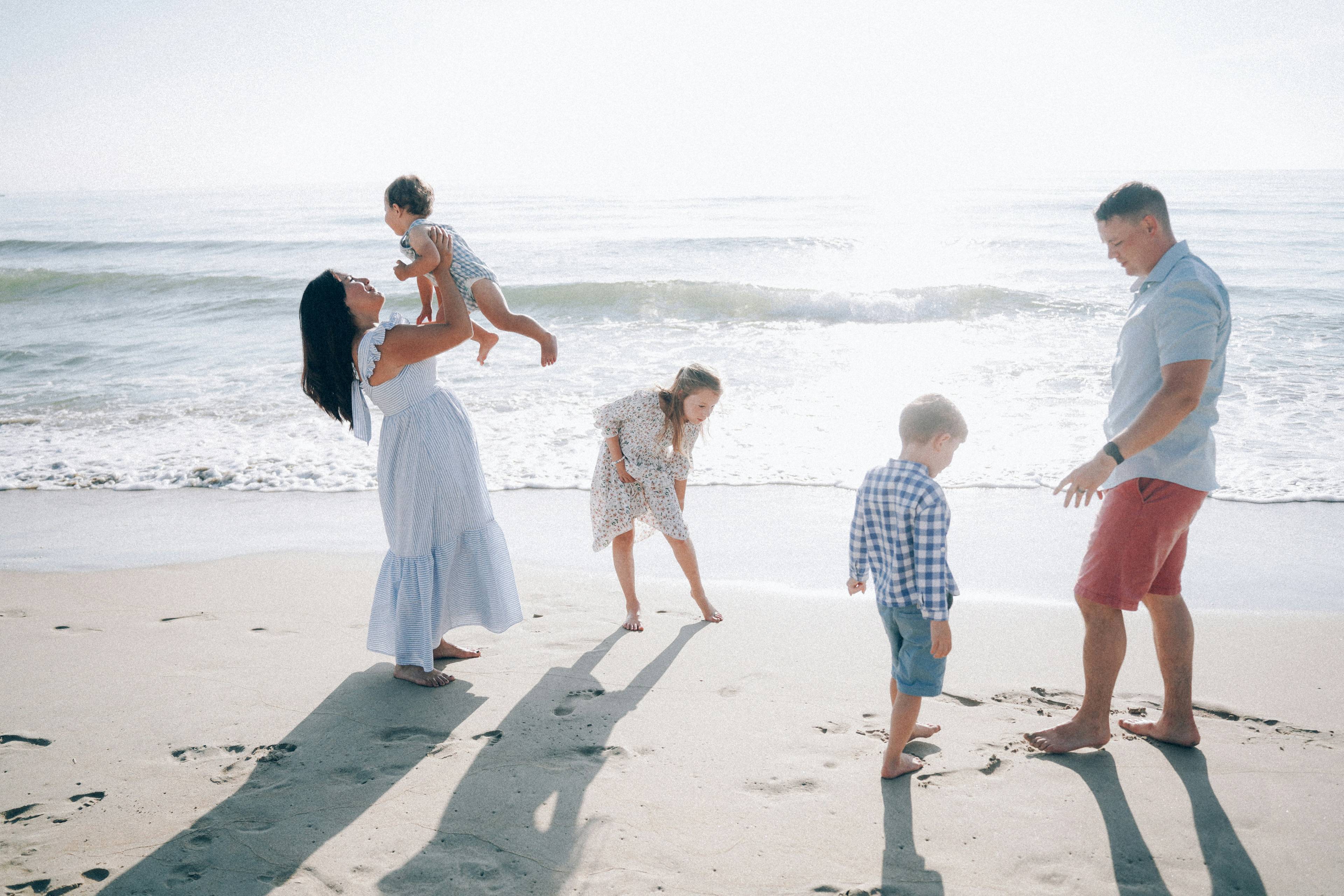 Families enjoying Newport Beach on a sunny day with children playing in the waves