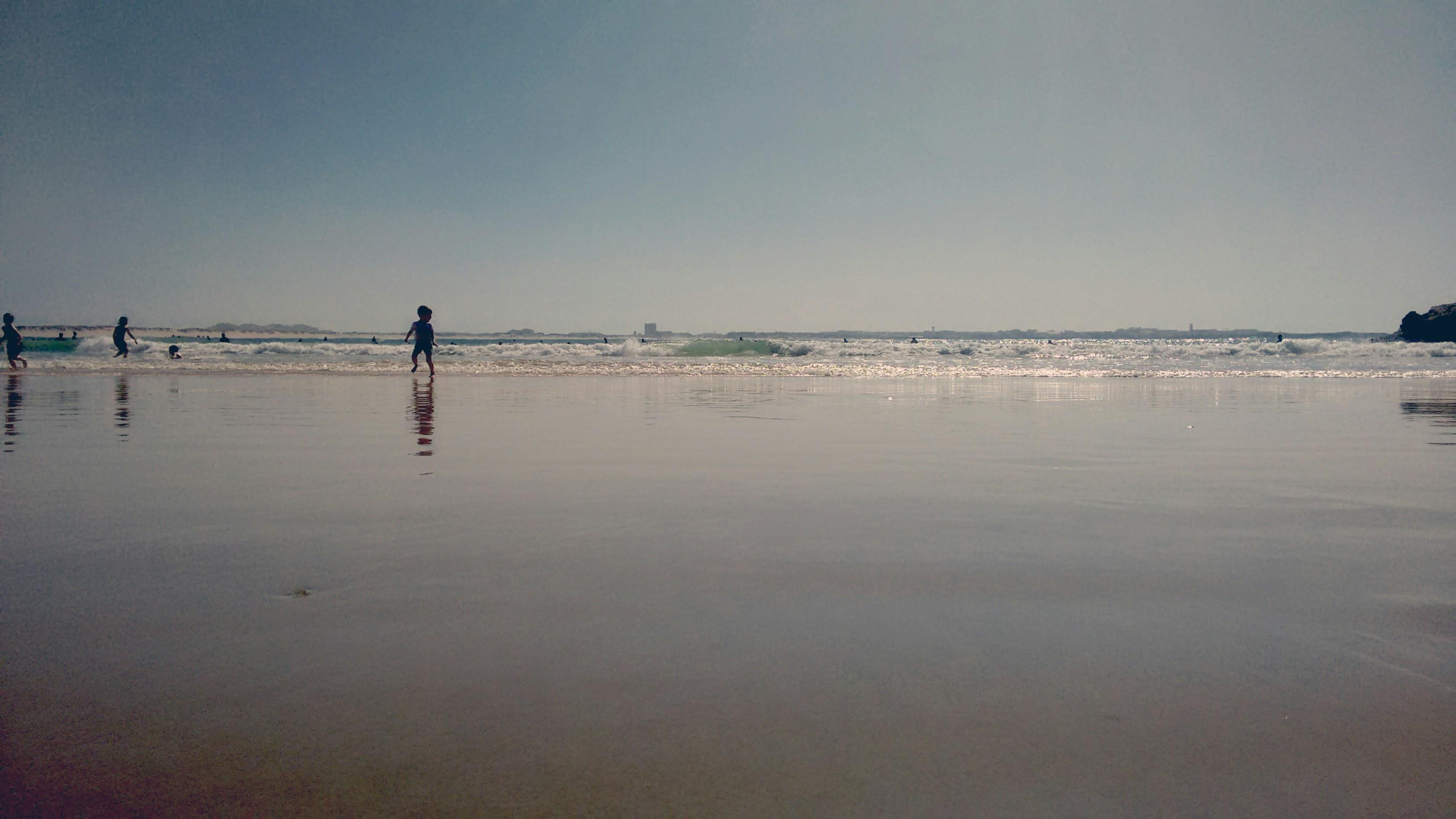 Families enjoying Newport Beach with children playing in the waves