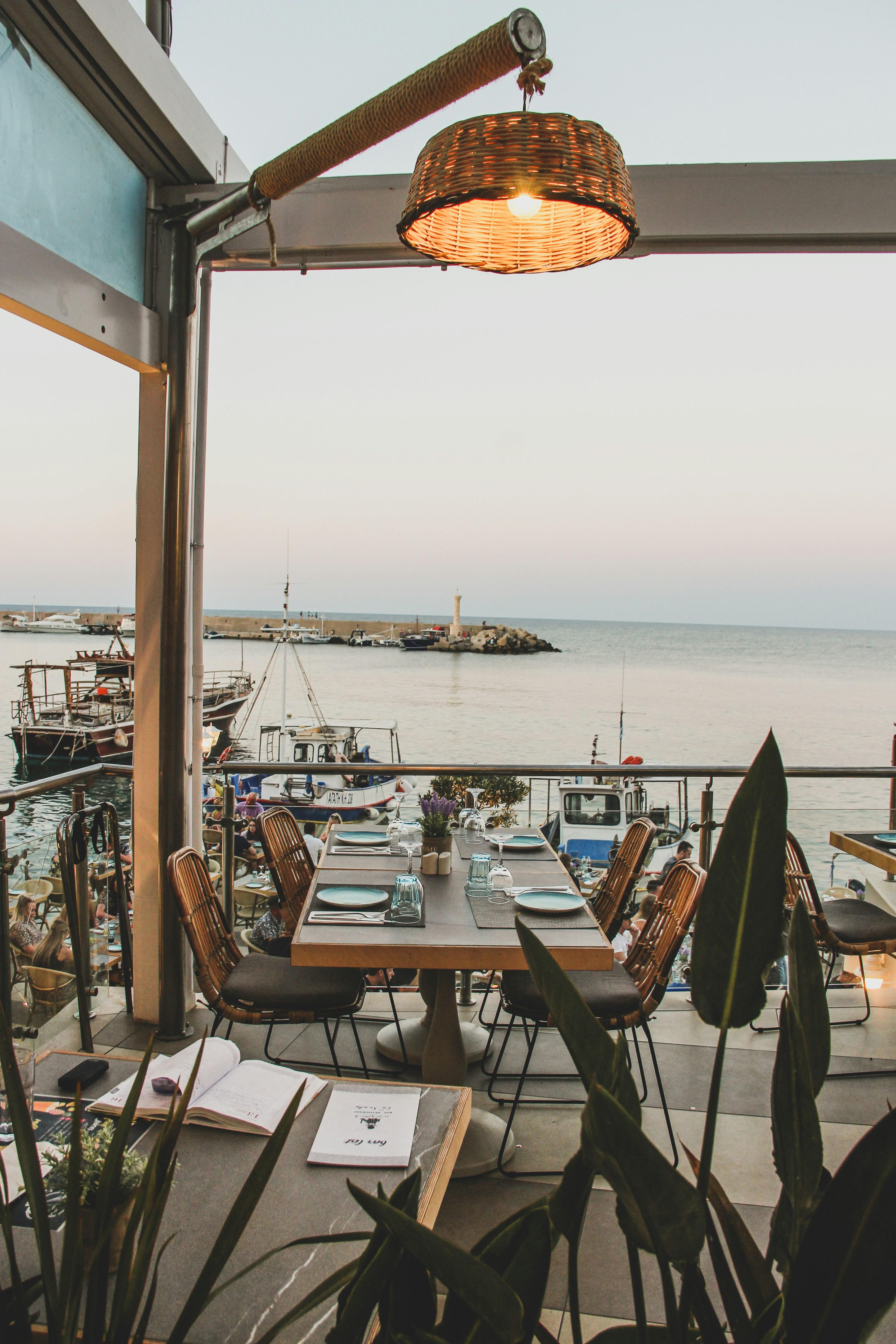 Elegant waterfront restaurant table with harbor views at dusk