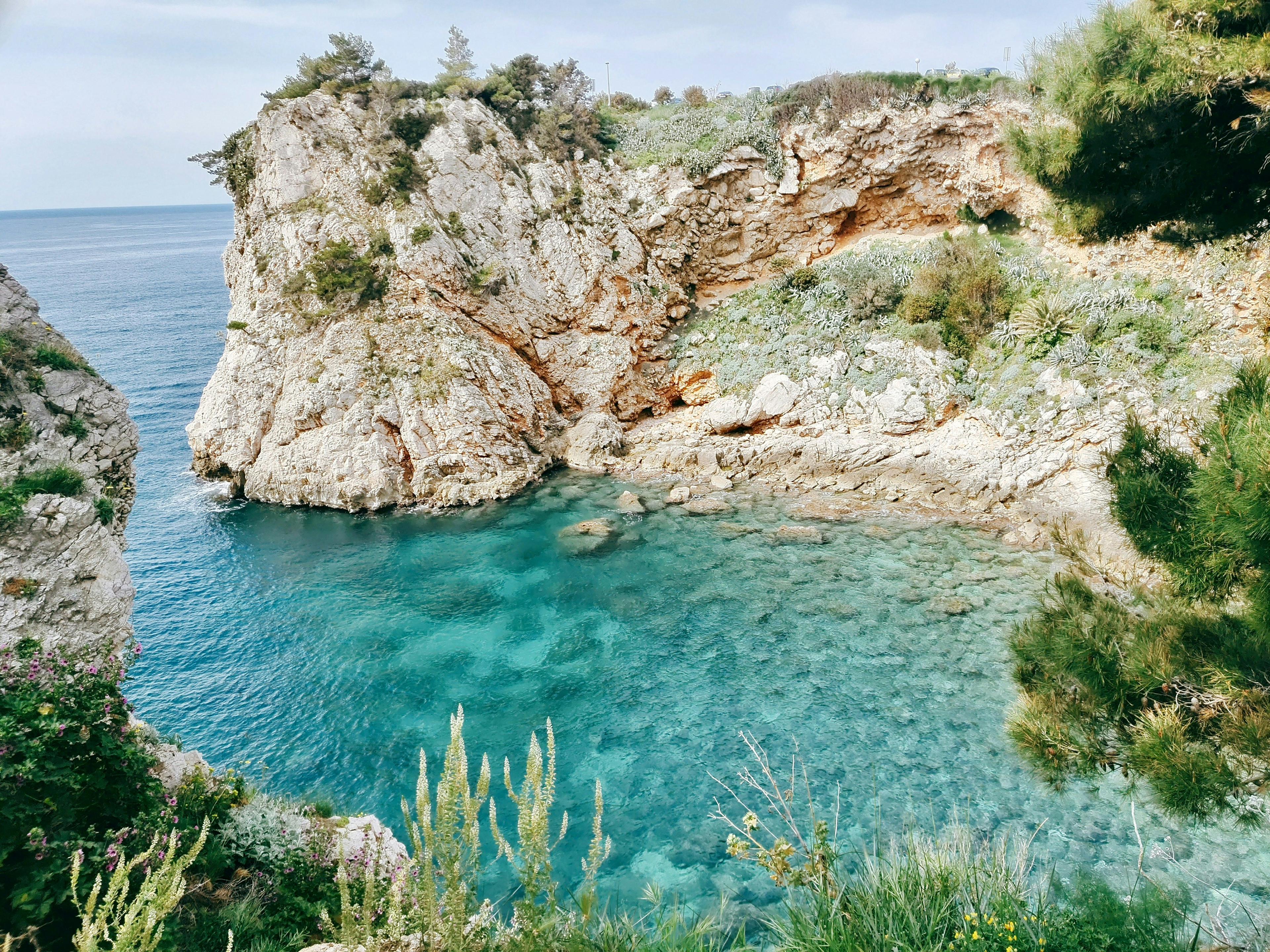 Corona del Mar beach cove with crystal clear water and rocky cliffs