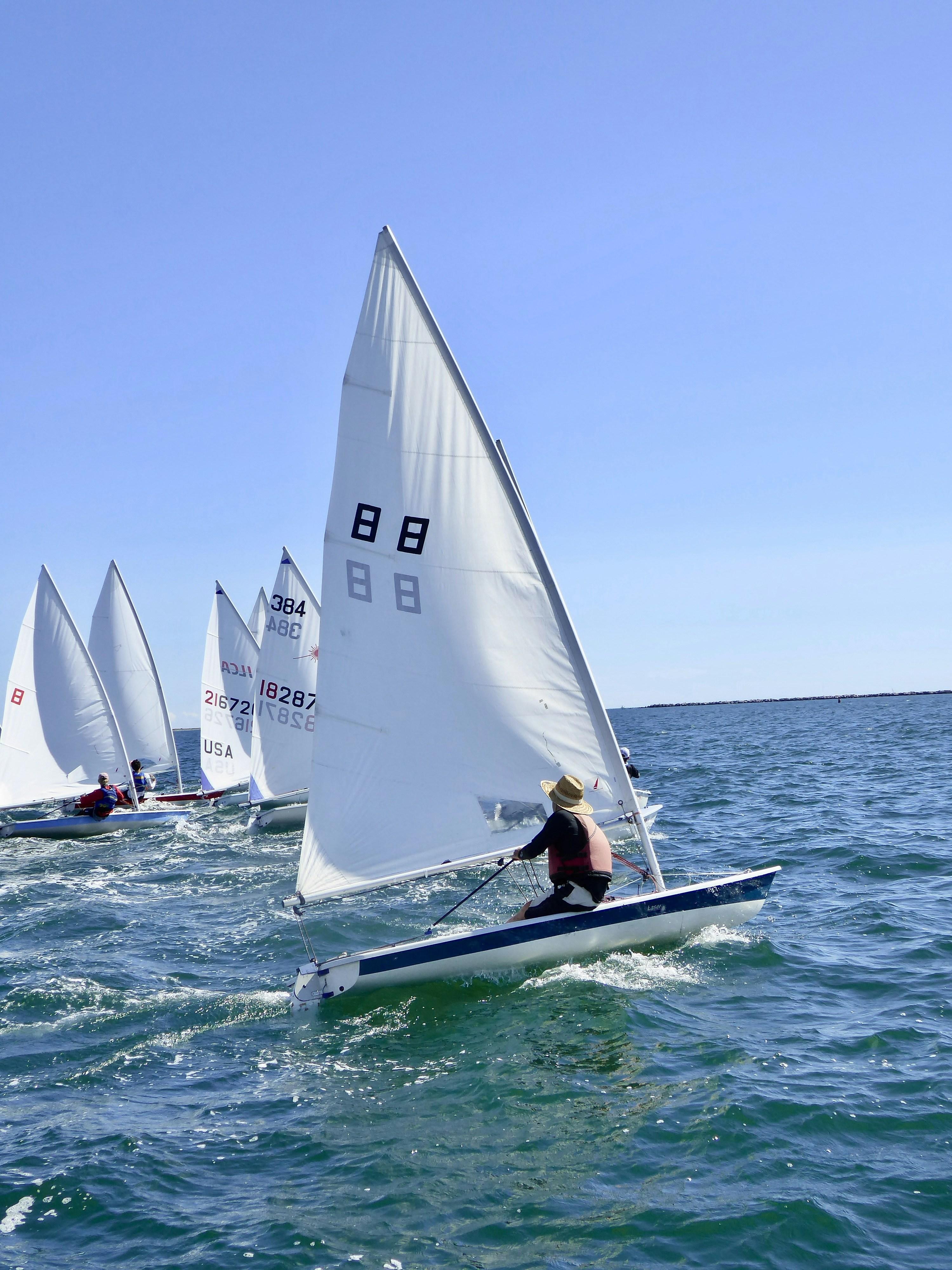 Balboa Yacht Club sailboats racing in Newport Harbor on a clear afternoon