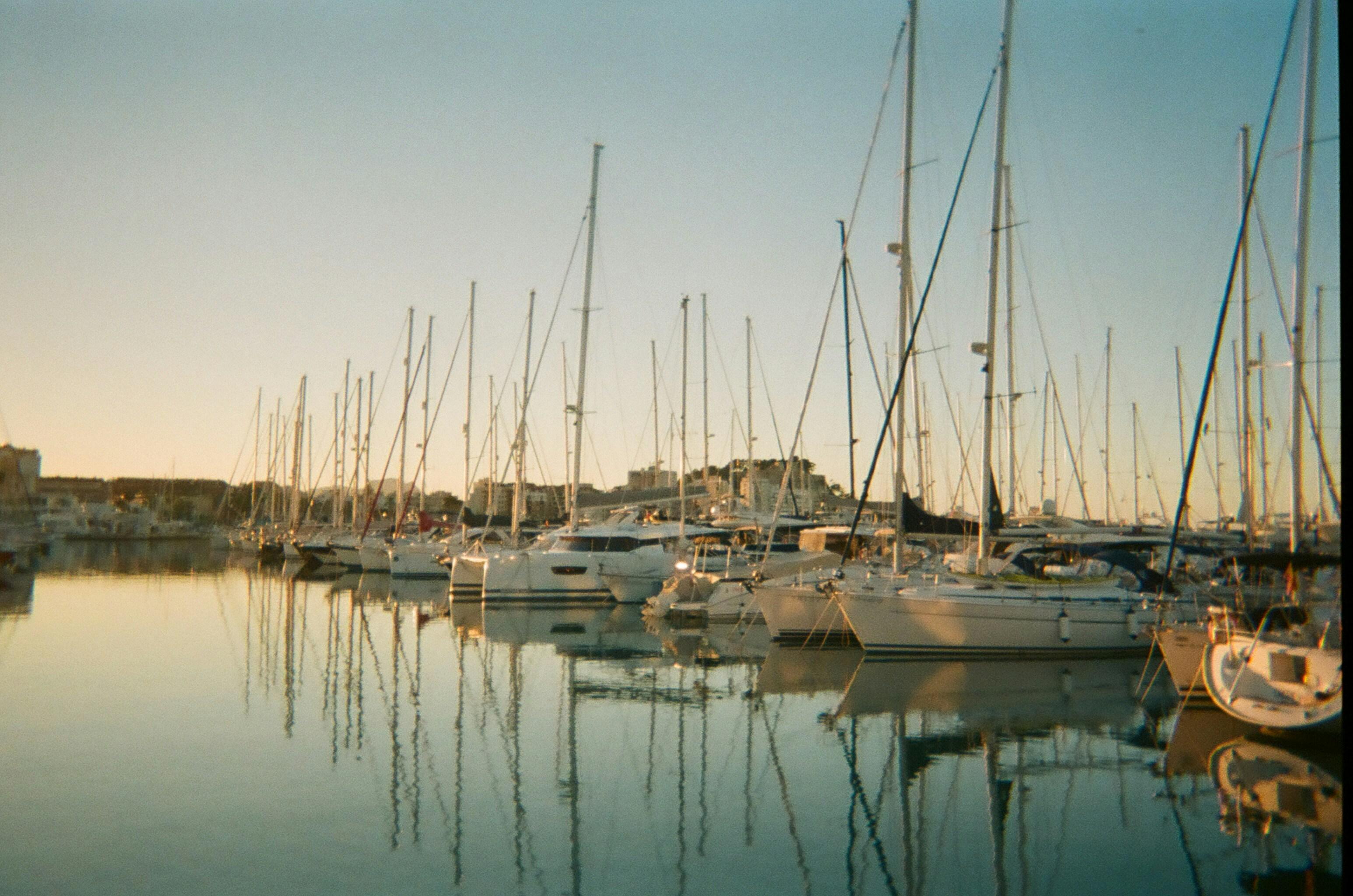 Newport Harbor at golden hour with sailboats and calm water