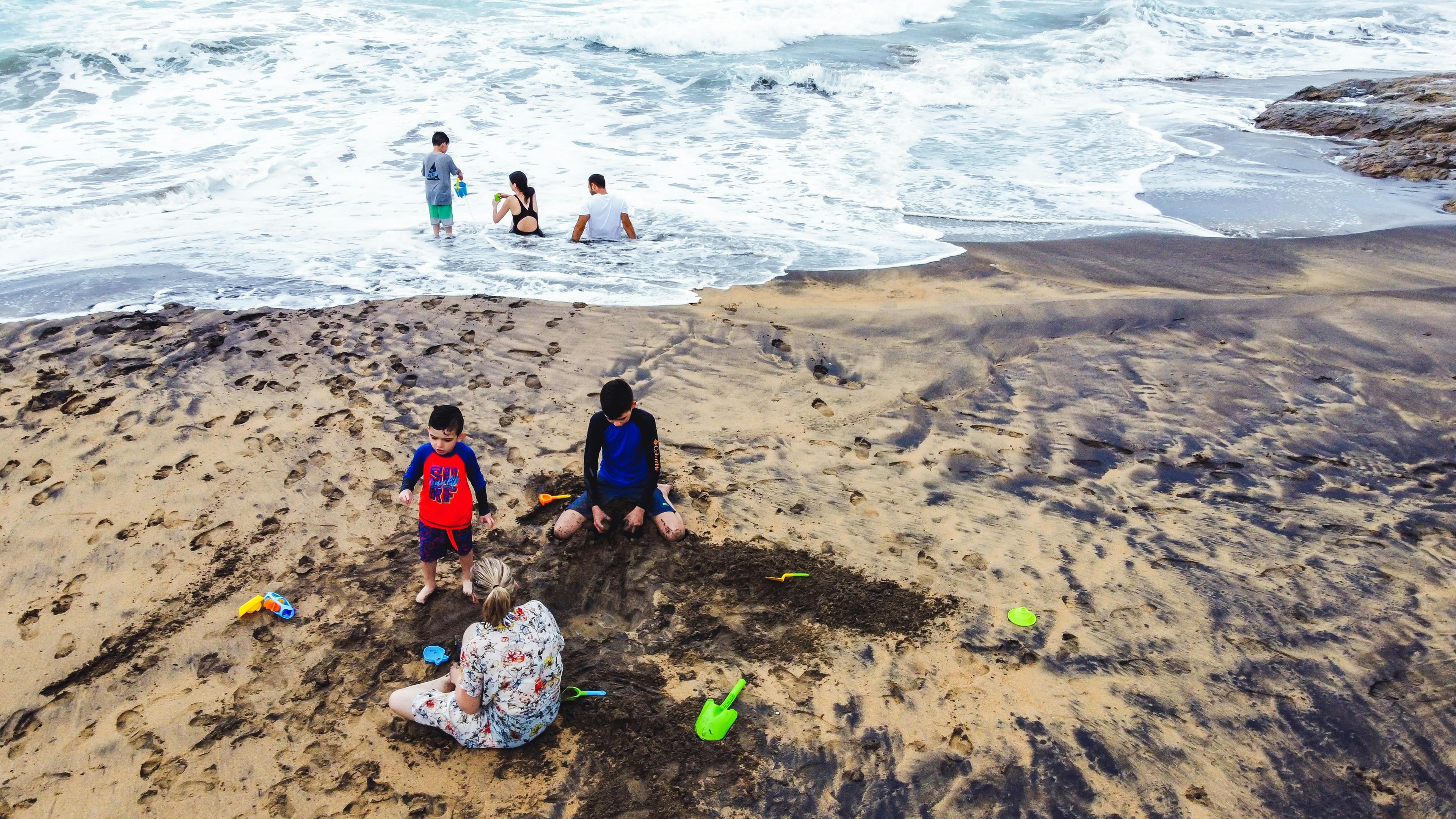 Family enjoying Newport Beach with children playing in the sand