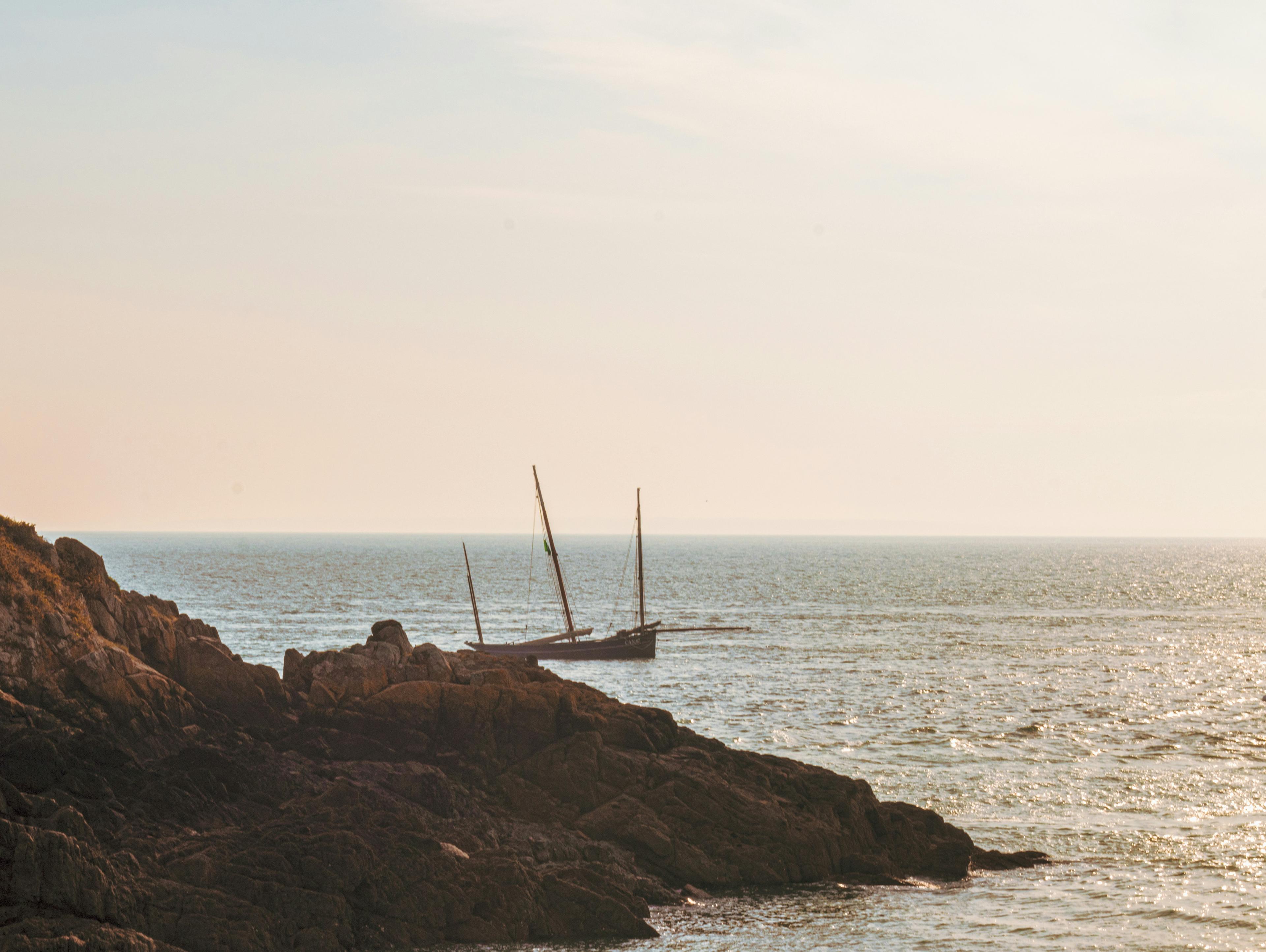 Catalina Island coastline at sunset with Two Harbors visible and sailboats anchored in the cove