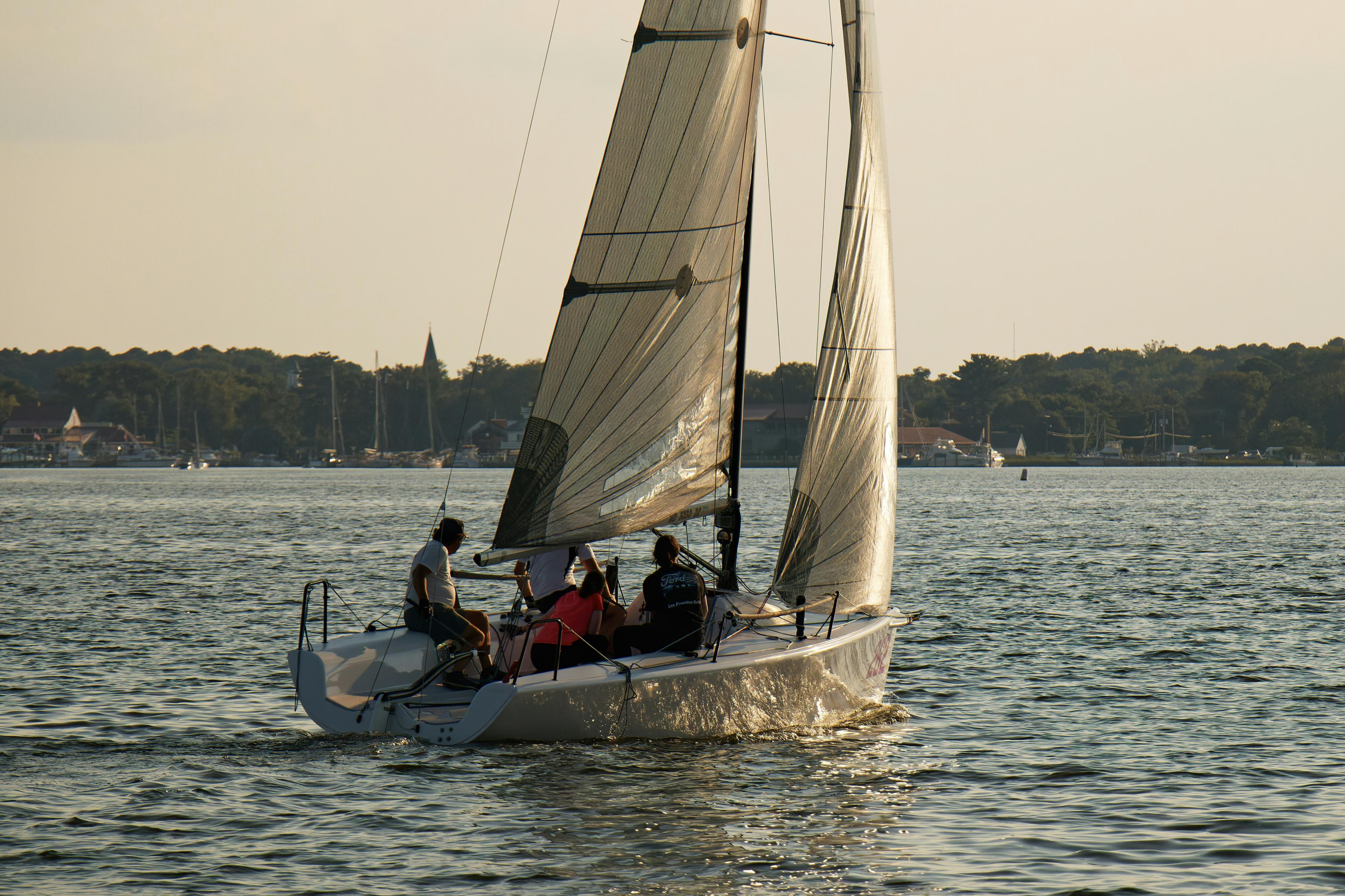 Duffy electric boat gliding through Newport Harbor at golden hour