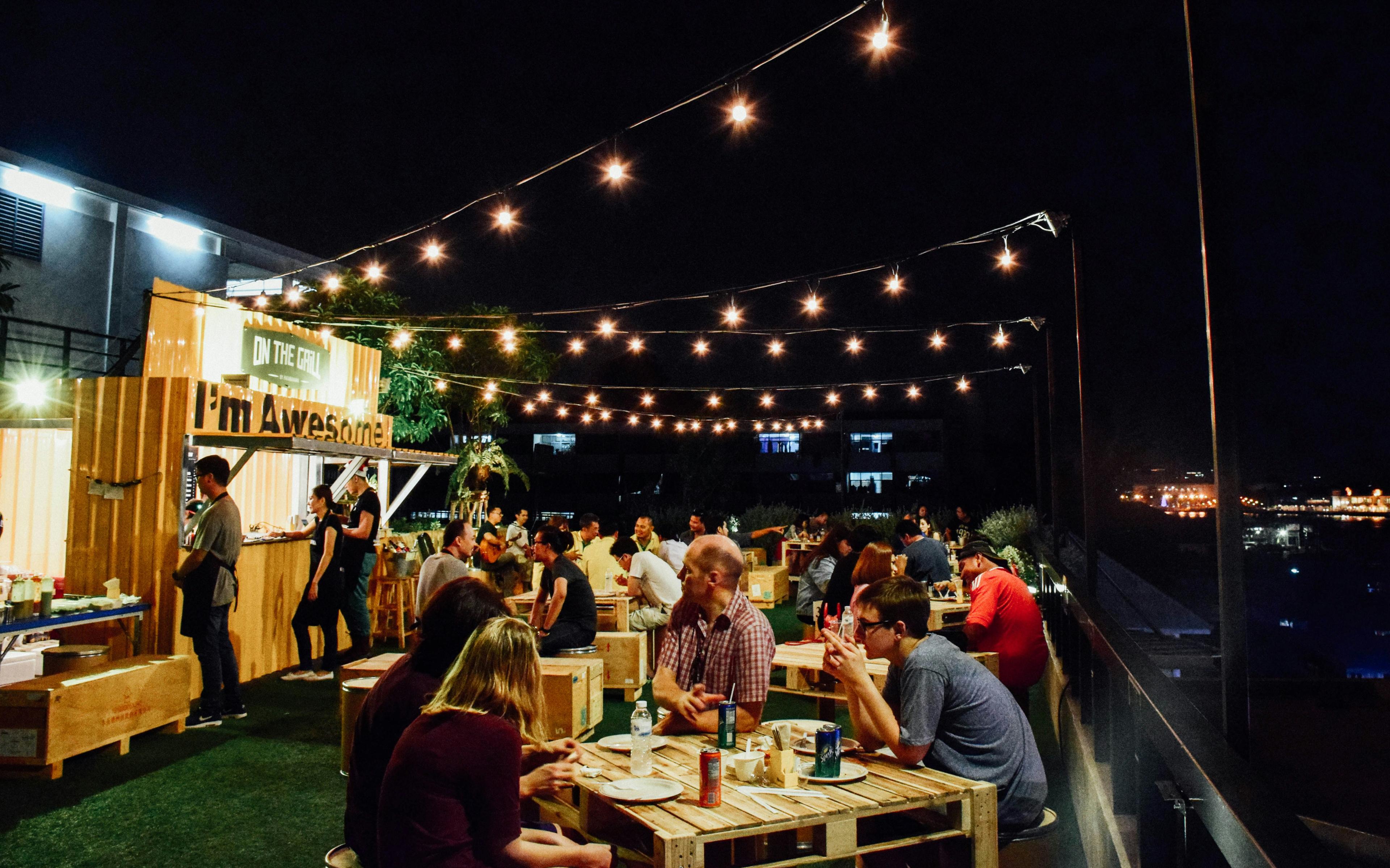 Casual outdoor restaurant patio with warm string lights and relaxed dining atmosphere