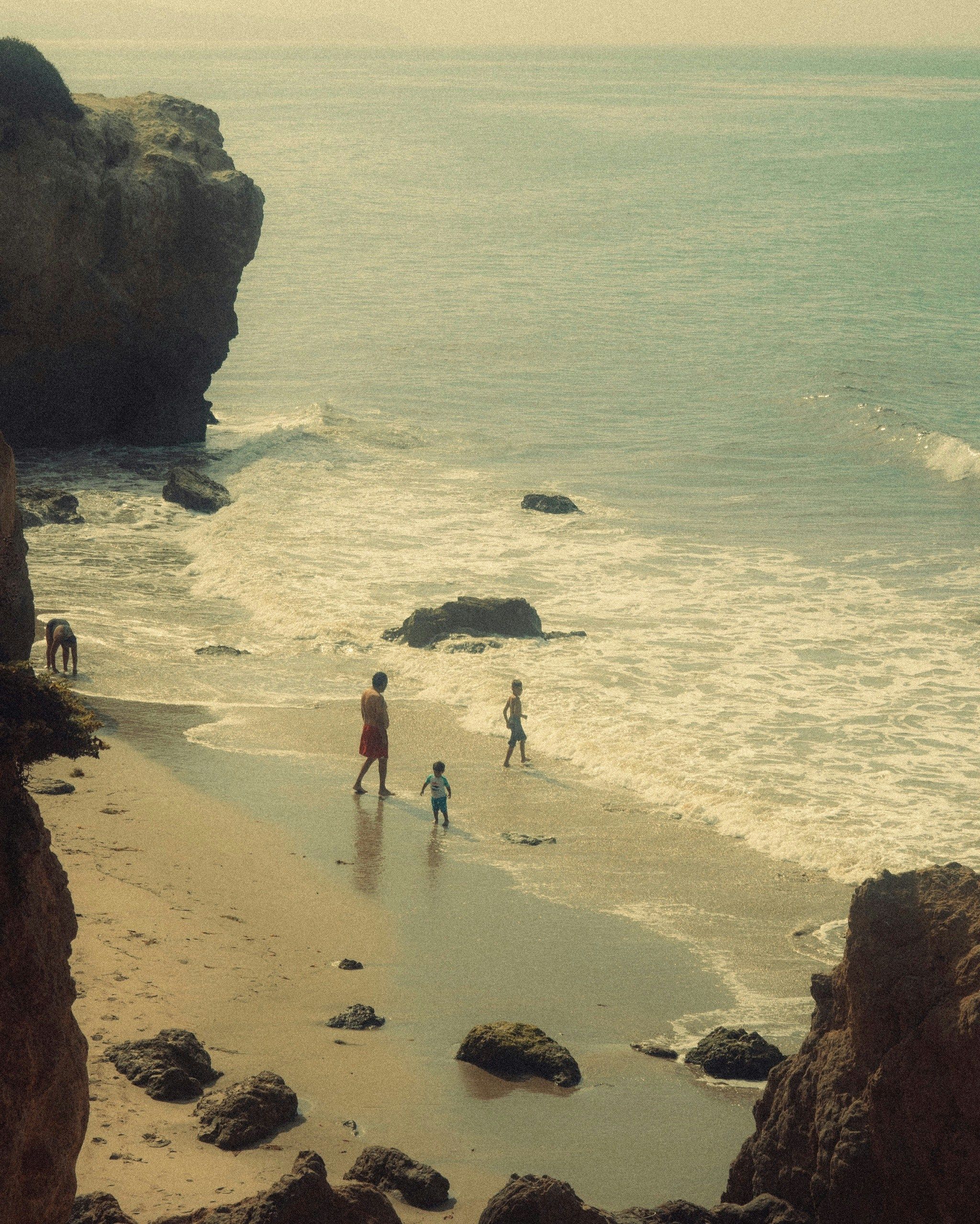 Family enjoying Newport Beach with children playing in the waves on a sunny day