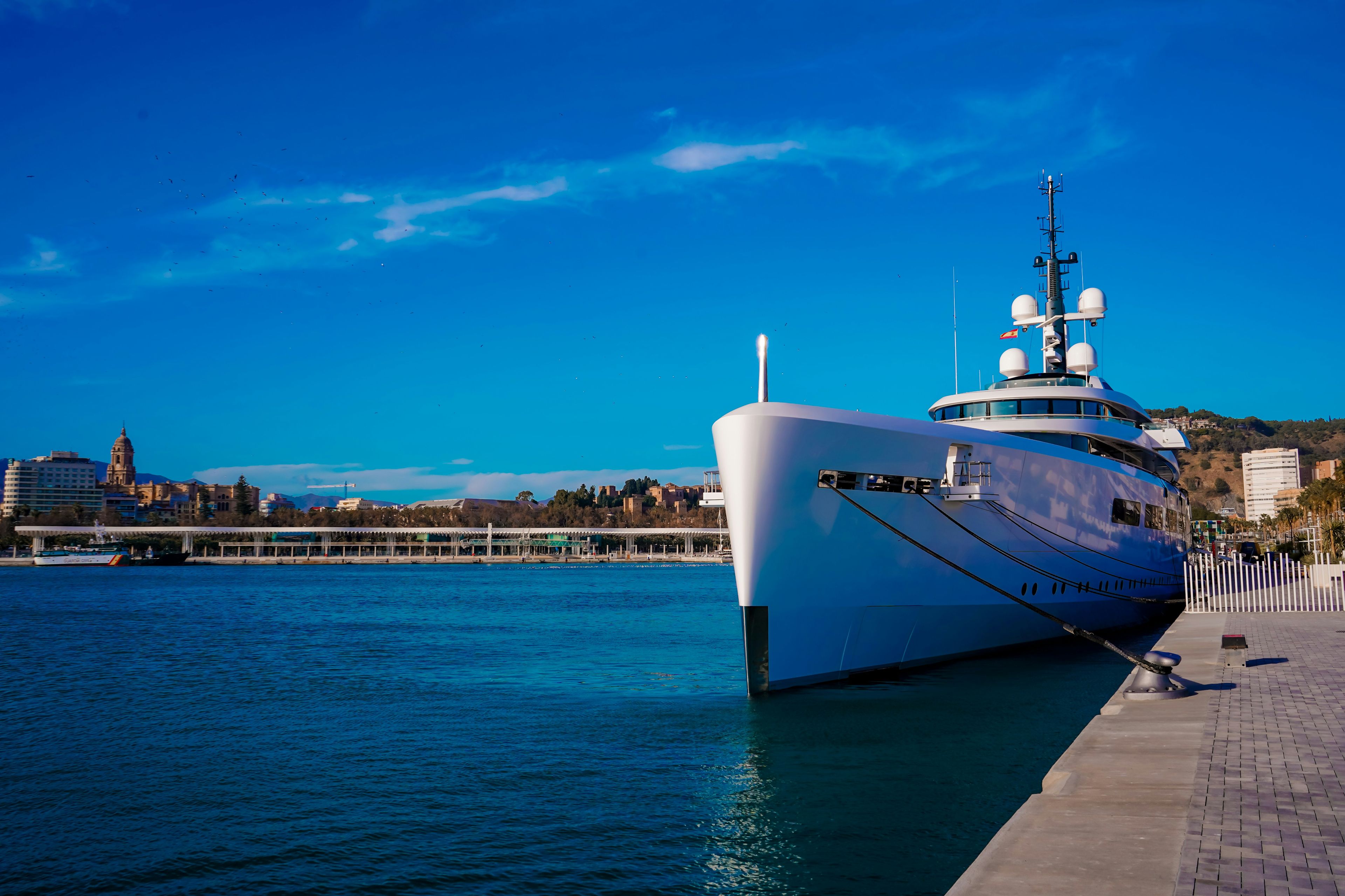 Private luxury yacht at sunset in Newport Harbor with the city skyline in the background